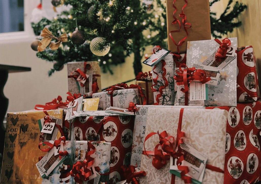 A pile of wrapped Christmas presents under the tree