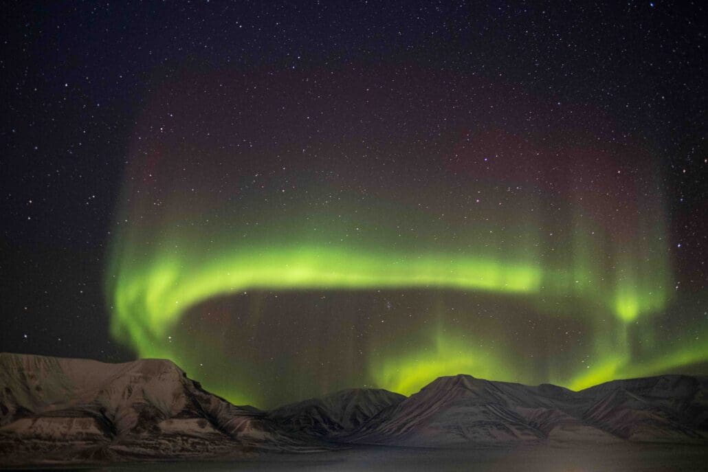 Bright green Northern Lights over the mountains